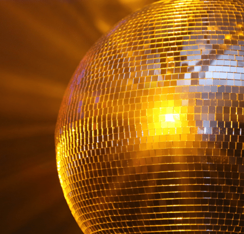 Disco Ball with yellow light shining on it.